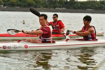 SAMA-SAMA MERIAHKAN ACARA: Encik Ong (depan) menyertai juara Sukan SEA, Mervyn Toh, dalam acara 'kayak berganda' sempena Maraton Kanu Singapura yang berlangsung kelmarin. - Foto THE STRAIT TIMES
