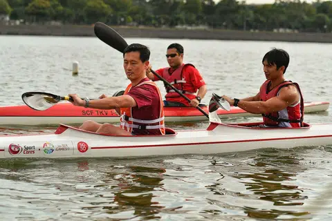 SAMA-SAMA MERIAHKAN ACARA: Encik Ong (depan) menyertai juara Sukan SEA, Mervyn Toh, dalam acara 'kayak berganda' sempena Maraton Kanu Singapura yang berlangsung kelmarin. - Foto THE STRAIT TIMES