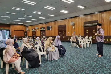 PEJUANG AL-QURAN: Pengerusi Eksekutif Kanan Masjid Ar-Raudhah merangkap Naib Pengerusi Majlis Tilawah & Tahfiz Al-Quran (MTTQ), Ustaz Mohamed Ali Atan (berdiri), memberi taklimat tentang MTTQ kepada kakitangan dan sukarelawan masjid.
