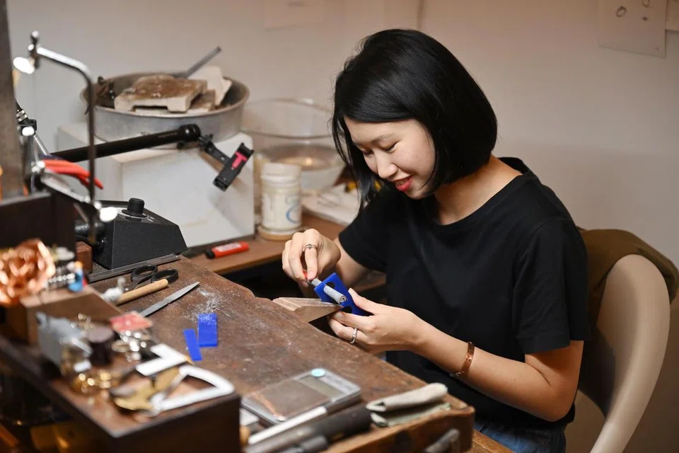 Cik Junie Lim dilihat sedang sibuk membuat barang kemas di kedai beliau, Clink Clank Clunk. 