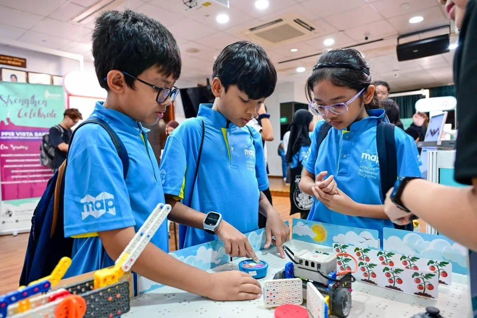 Beberapa murid Program Pencapaian Mendaki (MAP) mencuba kegiatan robotik kendalian perunding pendidikan VM Education, salah satu rakan kongsi Raikan Ilmu 2026.