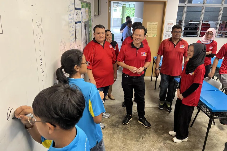 TINJAU PROGRAM: Menteri Negara Kanan (Pertahanan merangkap Tenaga Manusia), Encik Zaqy Mohamad (empat dari kanan), yang juga Timbalan Pengerusi Yayasan Mendaki, meninjau kelas pertama Program Tuisyen Mendaki bagi pelajar Menengah 2 di Sekolah Menengah Tampines pada 20 Januari.