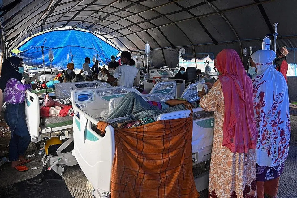 DIRAWAT: Sebilangan mangsa yang cedera ekoran gempa di kawasan bandar Mamuju sedang dirawat di sebuah khemah yang didirikan secara sementara di luar kawasan sebuah hospital. - Foto AFP