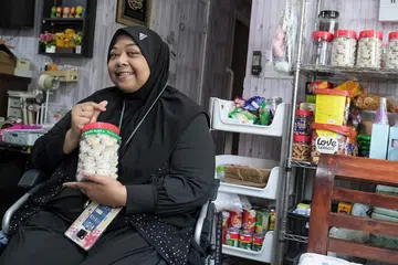 CARI REZEKI: Cik Mardiana Hassan, seorang balu yang telah kehilangan suami dan kededua kakinya, membuat perniagaan dari rumah dengan menjual kuih Raya dan juadah buka puasa setiap Ramadan. - Foto-foto BH oleh SHAFIQ APANDI 