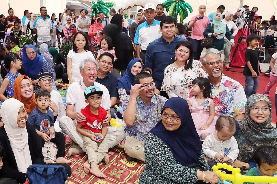 BERUSAHA TERUS PERTINGKAT MASYARAKAT: (Dua dari kiri, barisan kedua) Encik Teo, Encik Masagos dan Encik Zainal bersama-sama para penduduk Pasir Ris di majlis pelancaran M3di bandar itu semalam. Para penduduk dijangka meraih berbagai manfaat daripada program di bawah kerjasama M³. - Foto BH oleh GAVIN FOO