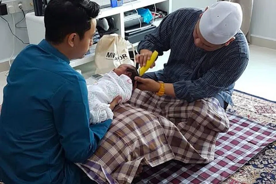 KHIDMAT CUKUR RAMBUT: Ustaz Lukmannul Hakeem (kanan), sedang menjalankan khidmat cukur rambut untuk pelanggan Aqiqah.sg. Selain khidmat tahnik, Aqiqah.sg juga menyediakan khidmat cukur rambut yang boleh disertakan dalam khidmat tahnik. 