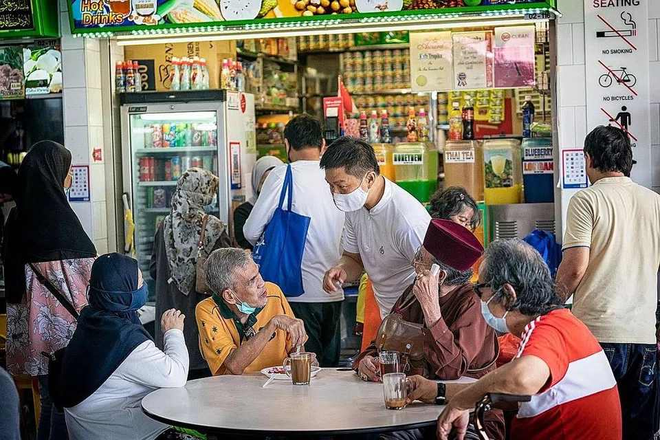 LAWAT PASAR GEYLANG SERAI: Encik Tan (berdiri) menyapa dan berbual dengan beberapa pengunjung pasar itu baru-baru ini. - Foto TAN CHUAN-JIN / FACEBOOK