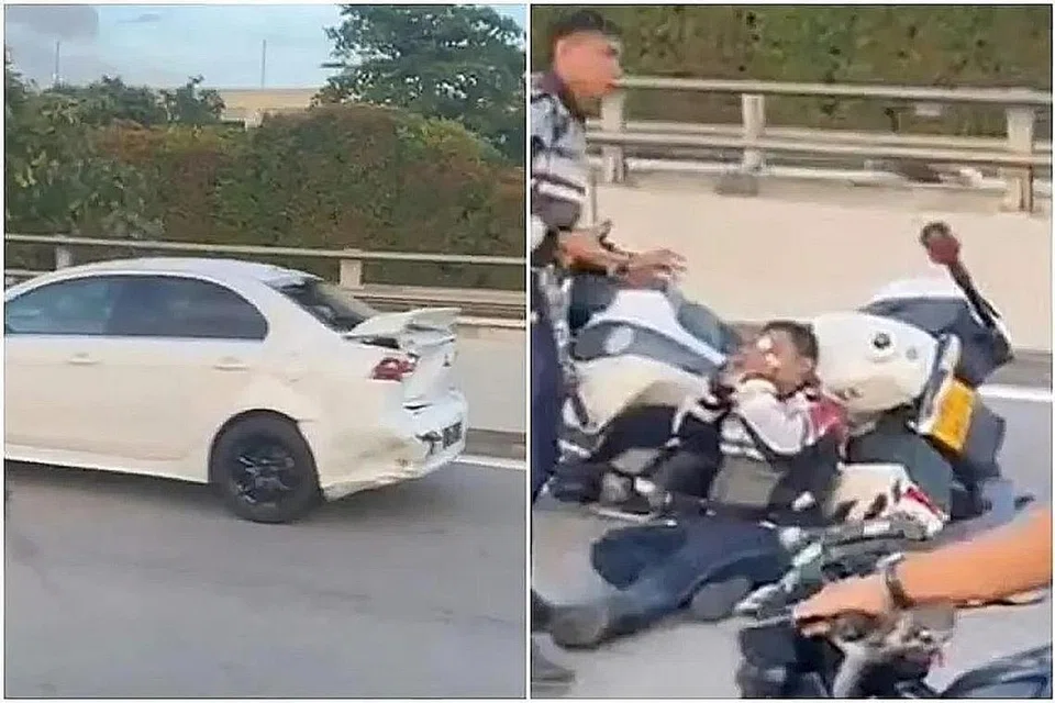 TERLIBAT DALAM KEMALANGAN: Seorang pegawai Polis Trafik (TP) dilihat dalam satu video sedang duduk di lorong paling kanan BKE, bersandar pada sebuah motosikal TP. - Foto-Foto TANGKAP LAYAR SGROAD BLOCKS/TRAFFIC NEWS/TELEGRAM