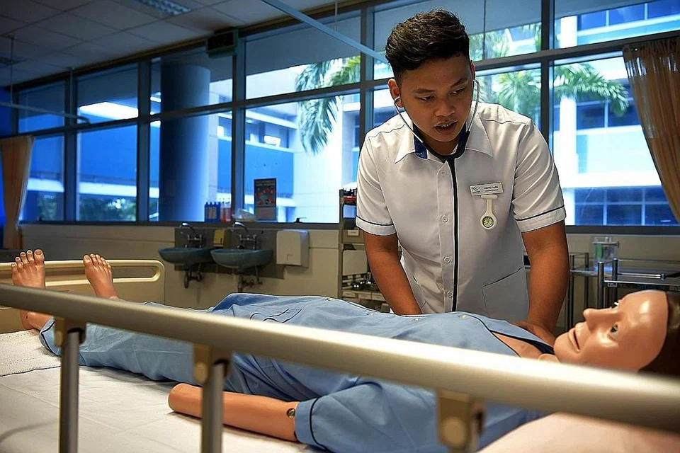 TEKUN JALANI LATIHAN: Encik Muhammad Nabil memeriksa degupan jantung 'dummy' yang digunakan di dalam bilik darjah kursus kejururawatan. - Foto BH oleh KUA CHEE SIONG