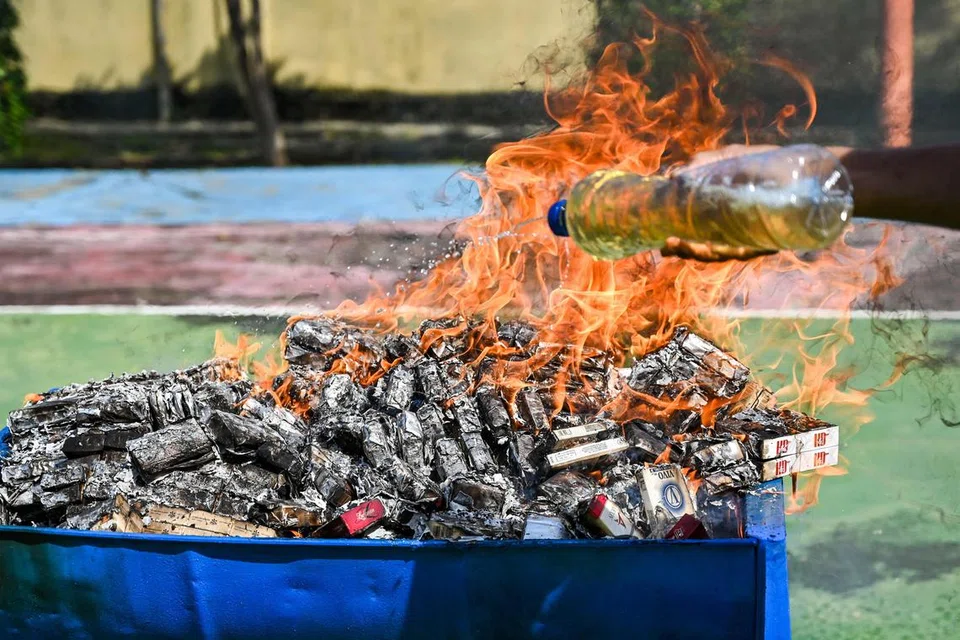 Pegawai kastam membakar barang seludup yang dirampas termasuk dadah dan rokok semasa sidang media di Banda Aceh pada 12 Disember 2024. 