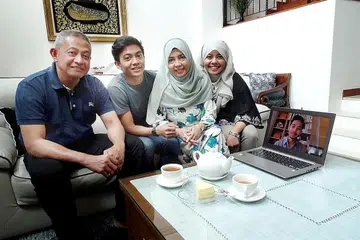 BERI SOKONGAN PENUH: Encik Mohd Aliffi Ismail dan isterinya, Cik Faezah Mohd Jaafar, memberi sokongan penuh kepada bidang yang diceburi anak. Mereka - bersama anak kedua, Encik Muhd Danial, dan anak bongsu, Cik Nur Qistina - 'skype' dengan anak sulung, Encik Muhd Nabil (di komputer). - Foto NAZRY MOKHTAR