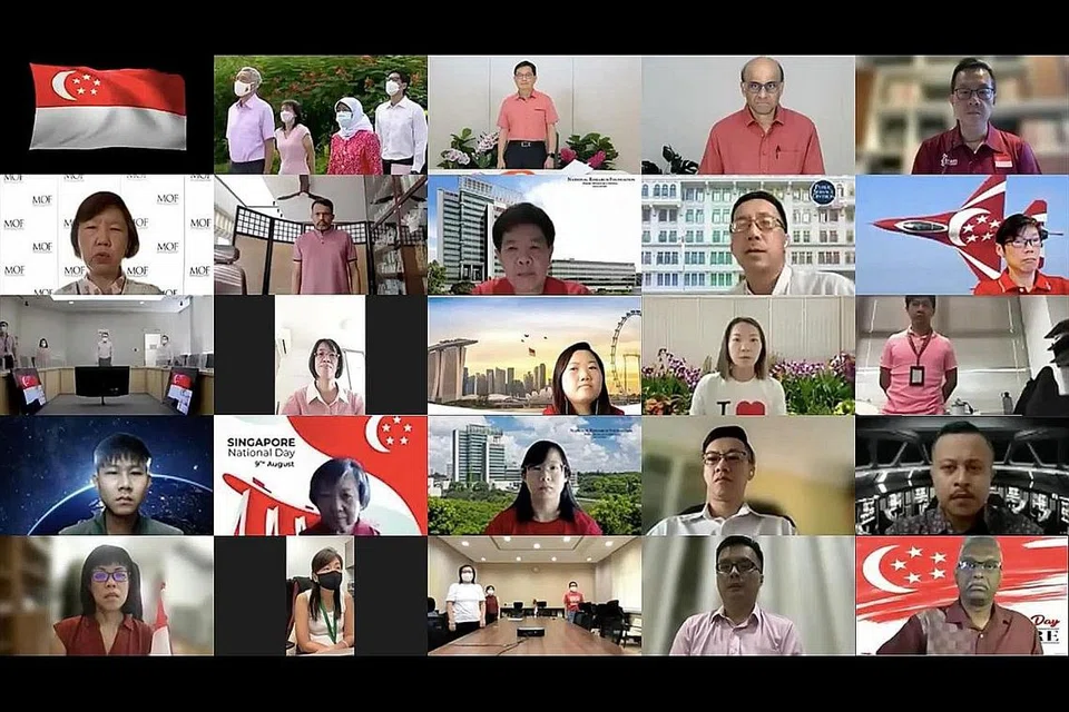 MENAIKKAN BENDERA: Presiden Halimah Yacob dan PM Lee Hsien Loong bersama beberapa pegawai daripada pejabat mereka berdiri penuh hormat di upacara menaikkan bendera Singapura. Mereka disertai penjawat awam lain alam talian pada Upacara Memperingati Hari Kebangsaan ini. - Foto PEJABAT PRESIDEN