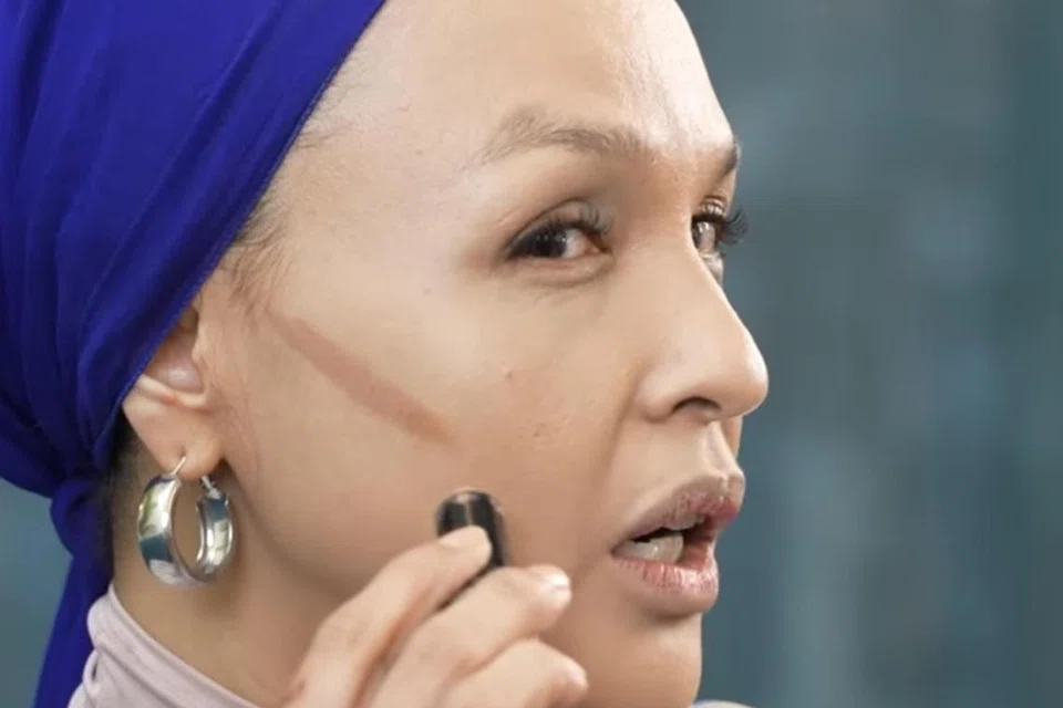 RUNCING: Noryn Aziz melukis garisan di pipi, atau kontur, untuk menghasilkan kesan pipi yang runcing 
