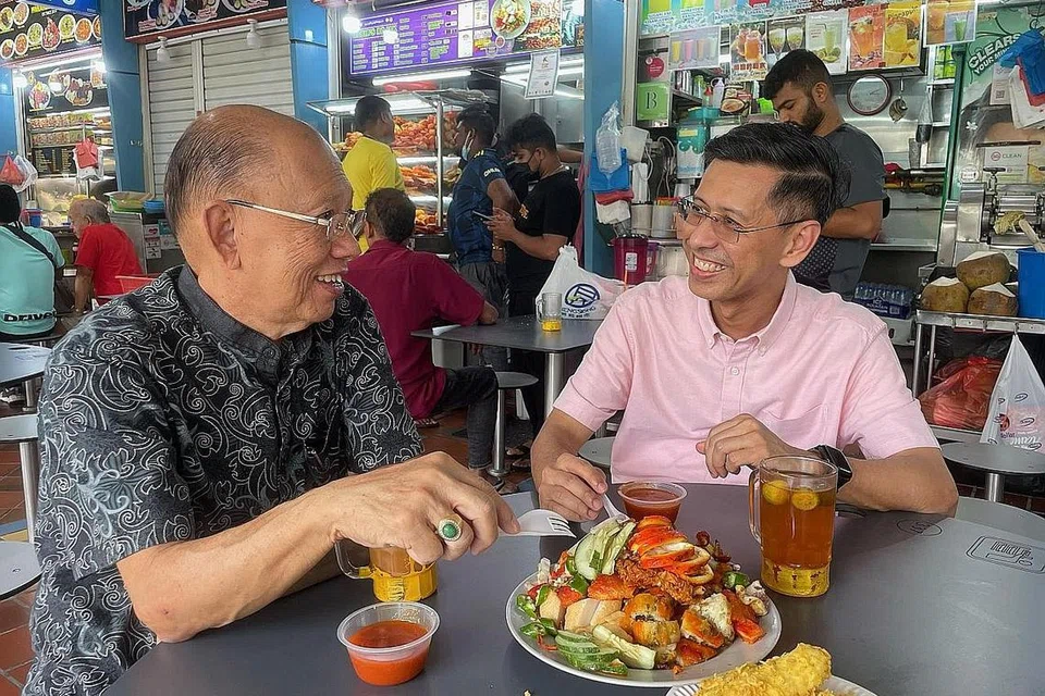 BERI MANFAAT KEPADA PENDUDUK: Encik Shahrin percaya pembinaan stesen baru di CRL2 akan memberi banyak manfaat positif bagi penduduk yang tinggal berhampiran seperti menikmati juadah yang sedap di Pusat Makanan Ayer Rajah. Bersama beliau adalah Pengerusi, Persatuan Peniaga West Coast Drive, Encik Bernard Thia Ang Hua. - Foto ihsan SHAHRIN ABDOL SALAM