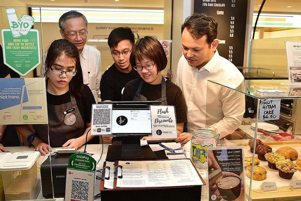 BERI PELUANG SAMA RATA: Menteri Negara (Sosial dan Pembangunan Keluarga merangkap Ehwal Luar), Encik Sam Tan (kiri) dan Encik Zaqy menyaksikan bagaimana Foreword Coffee berjaya melaksana proses mereka semula tugas khusus bagi menampung golongan berkeperluan khas. - Foto BH oleh DESMOND WEE