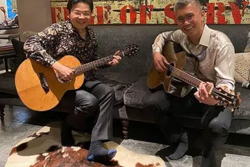 DILAYAN MESRA: Timbalan Perdana Menteri, Encik Lawrence Wong (kiri) bermain gitar bersama Menteri Kewangan Malaysia, Tengku Datuk Seri Zafrul Tengku Abdul Aziz. - Foto FACEBOOK LAWRENCE WONG