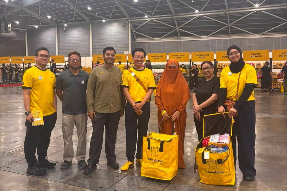 Penerima manfaat dibantu sukarelawan Maybank yang bertindak sebagai ‘pembeli peribadi’ ketika memilih barangan runcit dan keperluan harian bernilai sehingga $100 di Kindness Market di Dewan 4 Singapore Expo. (Dari kiri) Ketua Strategi Berasaskan Nilai dan Impak (Serantau), Pengurusan Kekayaan Islam Kumpulan, Maybank Singapura, Encik Zul Hakim Jumat; Pengurus Kanan Program dan Jangkauan Masyarakat Pertapis, Encik Md Noh Mohd Adam; Ketua Pegawai Eksekutif Pertapis, Encik Firdaus D’Cruz; Ketua Perbankan Islam Maybank Singapura, Encik Sazzali Sabandi; dua penerima manfaat, Cik Hadrawati Abdul Rahman; Cik Siti Norasikin Mohd Shah dan Pakar Kekayaan Islam; Cik Rufaidah Mohd Kamal.