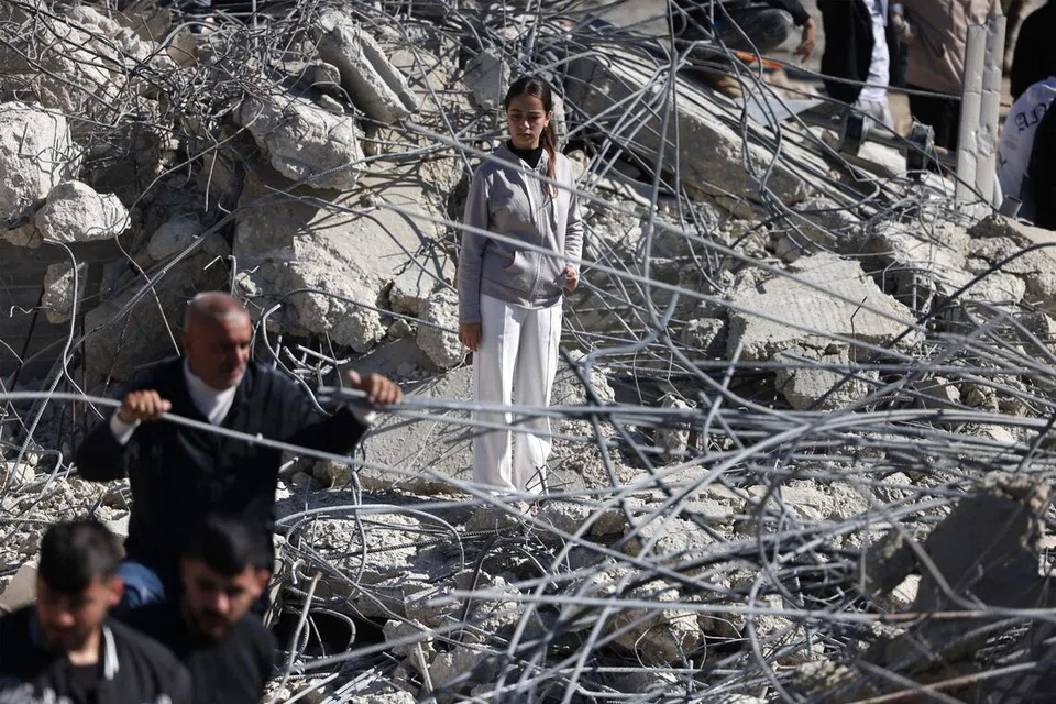 Seorang kanak-kanak perempuan Palestin berdiri di atas runtuhan konkrit dan besi daripada rumah serta kedai yang musnah selepas jentolak, yang dilindungi oleh pasukan keselamatan Israel, merobohkan bangunan kediaman milik keluarga Palestin di Beit Aawa, di barat bandar Hebron di Tebing Barat yang diduduki Israel, pada 5 Februari 2026. Israel, yang tenteranya menduduki Tebing Barat sejak 1967, kerap merobohkan rumah penduduk Palestin yang dituduh melakukan serangan maut terhadap warga Israel atau didakwa dibina tanpa permit yang dikeluarkan pihak berkuasa Israel. Pemerintah Israel mempertahankan tindakan tersebut atas alasan pencegahan, namun pengkritik mengecamnya sebagai satu bentuk hukuman kolektif yang menyebabkan keluarga kehilangan tempat tinggal.