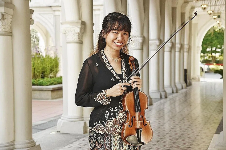 DEKATI AKAR BUDAYA SENDIRI: Pemain biola, Cik Noryn Sazali, yang terlatih secara klasik, mula menyertai Orkestra Sri Temasek tahun lalu dan belajar menyampaikan muzik tradisional Melayu. - Foto BH oleh DESMOND WEE