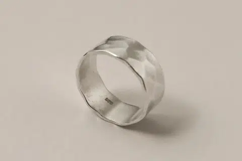 Cincin perak ‘matte’ bertekstur tidak sempurna ini menyerlahkan persona unik, seolah-olah menolak gaya konvensional.