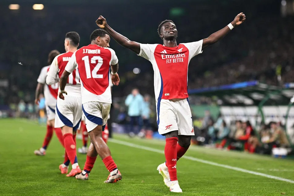 Pemain sayap, Bukayo Saka, meraikan golnya ketika menentang Sporting Lisbon dalam Liga Juara-Juara di stadium Estádio José Alvalade pada 27 November.