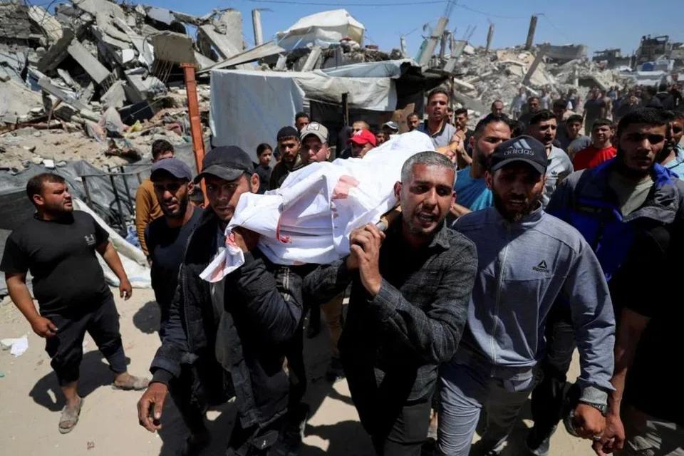 Orang ramai mengusung jenazah seorang rakyat Palestin selepas serangan Israel ke atas sebuah sekolah kendalian Pertubuhan Bangsa-Bangsa Bersatu (PBB) yang menempatkan penduduk kehilangan tempat tinggal, di luar kawasan sekolah di kem pelarian Jabalia, di utara Jaluran Gaza.