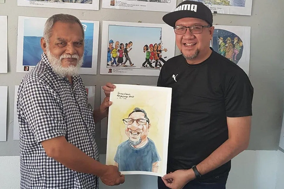 TERHARU MEWAKILI SINGAPURA: Encik Mohamad Idham (kanan) gembira dapat menyumbang kartun tentang kesan telefon bimbit (di tengah, di tembok balai seni) bagi Pameran Kartun Antarabangsa di Balai Kartun Rossem di Kota Bharu, Kelantan. Pemilik balai kartun, Encik Rosidi Ismail (kiri), yang juga dikenali sebagai Rossem, yang menyampaikan karikatur wajah Encik Mohamad Idham, adalah pelukis kartun politik popular di Malaysia. - Foto ihsan MOHAMAD IDHAM MOKARON