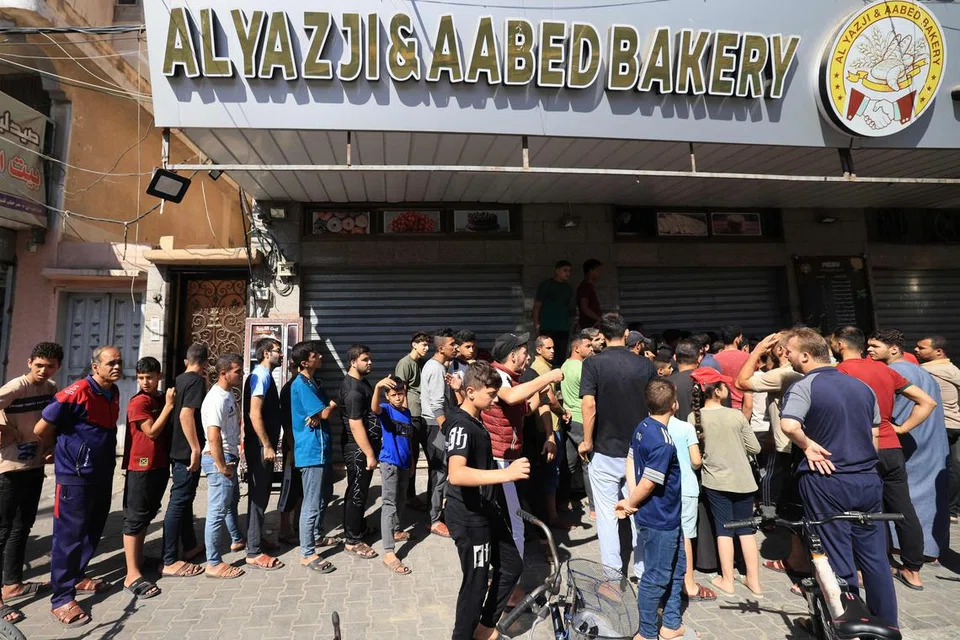 KRISIS KEMANUSIAAN: Penduduk Palestin beratur untuk mencari roti di Khan Yunis, selatan Jaluran Gaza pada Ahad sedang tentera Israel bersiap sedia untuk menawan Kota Gaza dan melumpuhkan kumpulan Hamas.