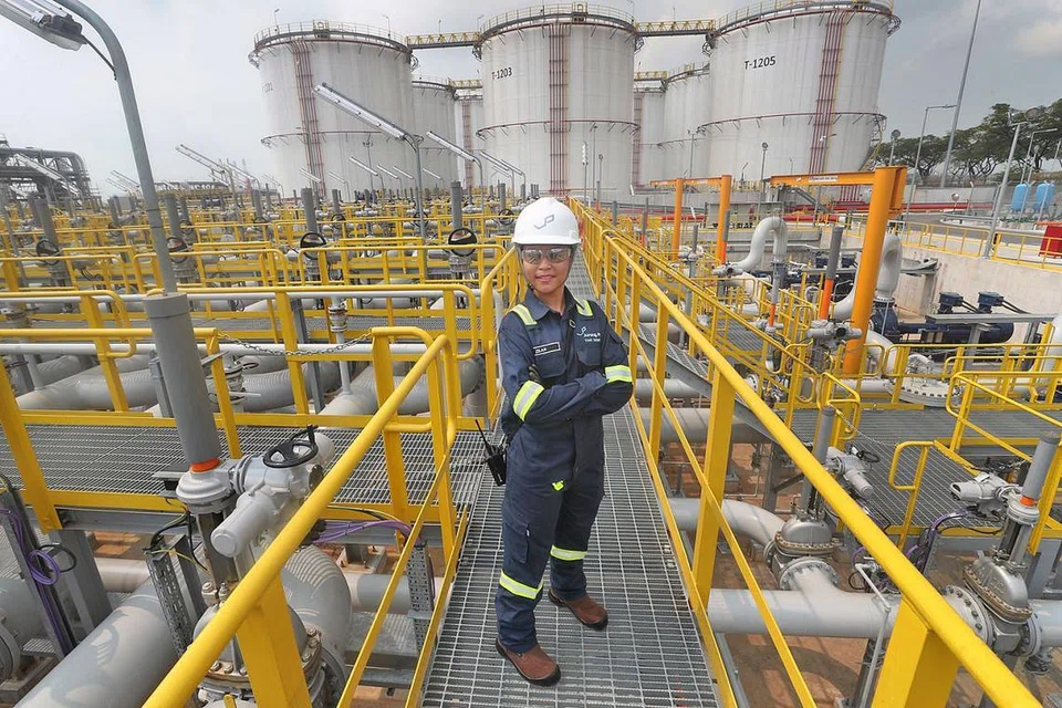 SAHUT CABARAN: Cik Nurazilah (atas) merupakan eksekutif Kesihatan, Keselamatan, Pertahanan dan Sekitaran (HSSE) dan pekerja operasi wanita pertama di Jurong Port Tank Terminals (JPPT)- kerjaya yang memang jarang diceburi kaum Hawa. - Foto BM oleh TIMOTHY DAVID