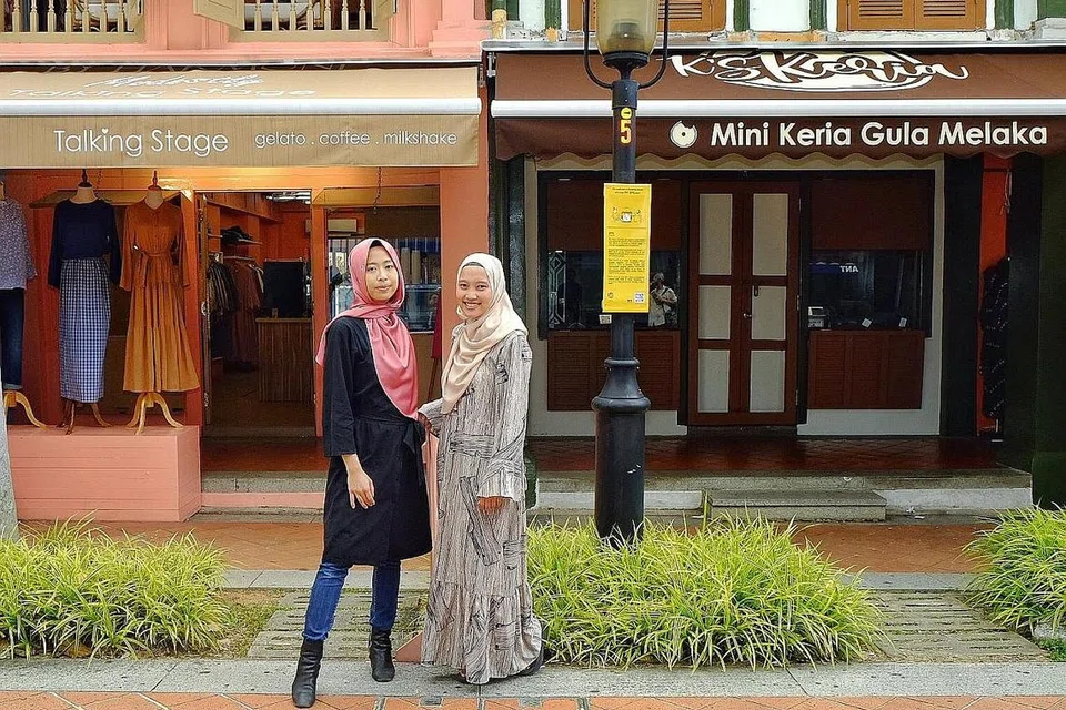 'ORANG BARU': Cik Aisyah (kiri) dan Cik Fatin berhadapan kedai mereka di Bussorah Street yang dibuka semasa pandemik. - Foto BH oleh Mohd Khalid Baba