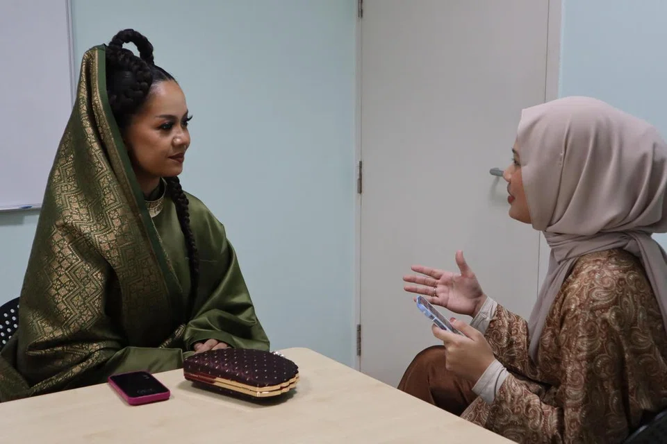 Penyanyi lagu ‘Serumpun’ dan ‘Angkat’ (kiri) semasa wawancara bersama wartawan Berita Harian, Ainin Alfiyani Jailani, di acara sambutan Hari Raya di Kampung Admiralty Community Plaza pada 24 April. 