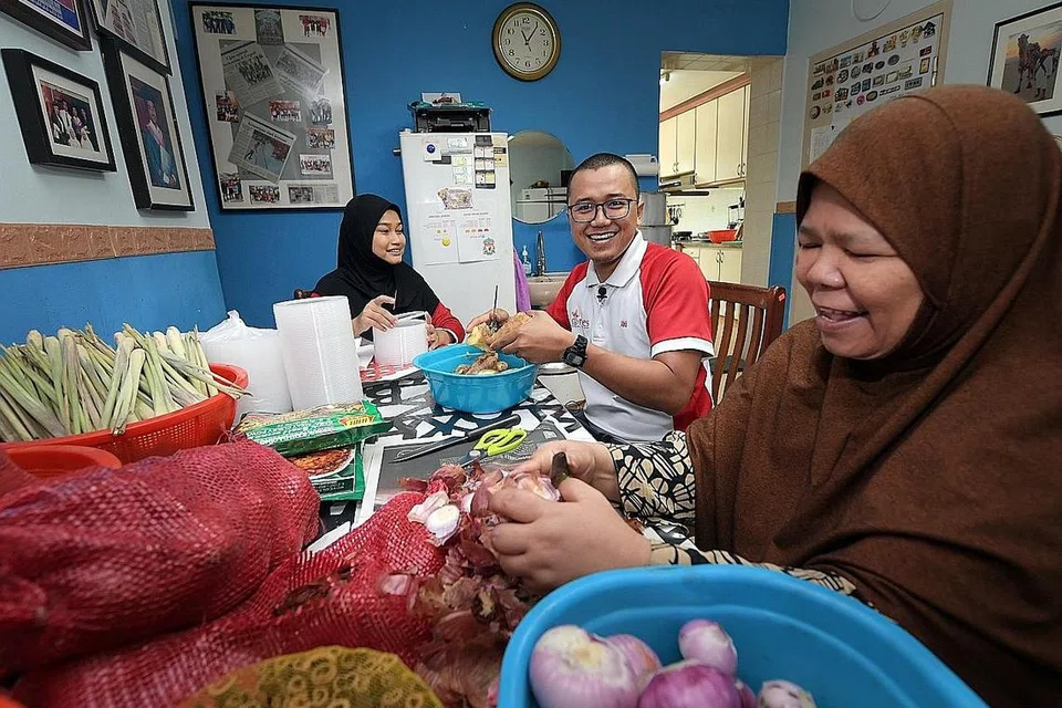 KEMBALI SEDIAKAN BUBUR: Perniagaan di rumah, Dapur Naes, dapat kembali menyediakan bubur kepada Masjid Jamiyah Ar-Rabitah semasa Ramadan ini selepas tidak dapat berbuat demikian tahun lalu dek langkah pemutus litar. Namun, kali ini persiapan membuat bubur itu tidak dilakukan di perkarangan masjid tetapi di rumah mereka sendiri, kata pengendali utama perniagaan tersebut, Encik Muhammad Izzaki Nasir (tengah).