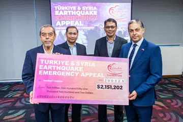 JUMLAH TERTINGGI DIKUMPUL: Cek berjumlah $2,151,202 diserahkan Pengerusi Lembaga Pemegang Yayasan Rahmatan Lil Alamin, Encik Abdul Razak Maricar (paling kiri) kepada Duta Republik Turkey bagi Republik Singapura, Encik Mehmet Burçin Gönenli, (paling kanan), yang menerima cek itu bagi pihak Hayrat Yardim. - 