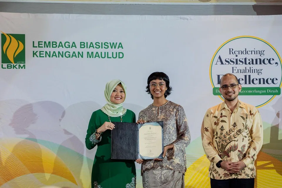 SAMPAIKAN ANUGERAH: Setiausaha Parlimen Kanan (Kesihatan merangkap Undang-undang), Cik Rahayu Mahzam (kiri), menyampaikan  Anugerah Biasiswa kepada penerima, Cik Sarah Noorhimli, disaksikan Presiden LBKM, Dr Syed Harun Taha Alhabsyi.