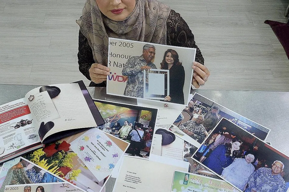 HARGAI PENGHARGAAN: Cef Siti Mastura menunjukkan gambar beliau bersama mendiang Presiden Nathan yang telah menempah kek 'fudge' durian daripadanya. - Foto fail