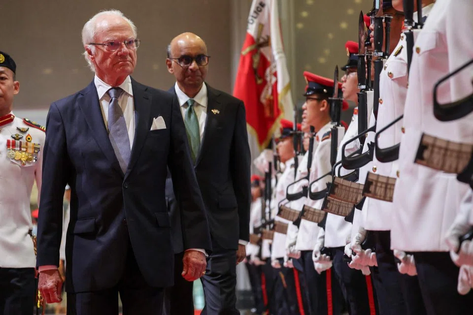 Raja Sweden Carl XVI Gustaf (kiri) memeriksa kawalan kehormatan bersama Presiden Tharman Shanmugaratnam di Parliament House di Singapura pada 19 November.