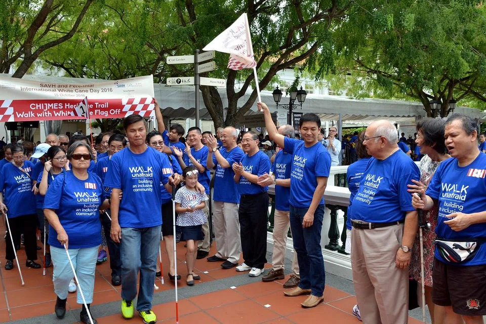 MULAKAN ACARA: Menteri Pembangunan Sosial dan Keluarga, Encik Tan Chuan-Jin, kelihatan sedang mengibarkan bendera menandakan permulaan acara berjalan jejak warisan.