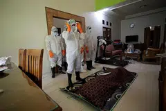 MENYEMPURNAKAN JENAZAH: Anggota polis lengkap berpakaian pelindung diri melakukan sembahyang jenazah mangsa yang meninggal dunia pada usia 86 tahun akibat komplikasi yang ada kaitan dengan Covid-19 di Bogor, Indonesia. - Foto REUTERS
