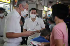 DEKATI PENDUDUK: Perdana Menteri Lee Hsien Loong (kiri) bersama calon PAP bagi SMC Yio Chu Kang, Encik Yip Hon Weng, bertemu penduduk di pusat penjaja di Blok 628 Ang Mo Kio Avenue 4 semalam. - Foto BH oleh JASON QUAH