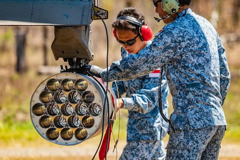 PEMERIKSAAN TELITI: Askar tentera udara melakukan pemeriksaan ke atas helikopter Apache AH-64D sebelum latihan menembak menggunakan peluru hidup bermula. - Foto MINDEF