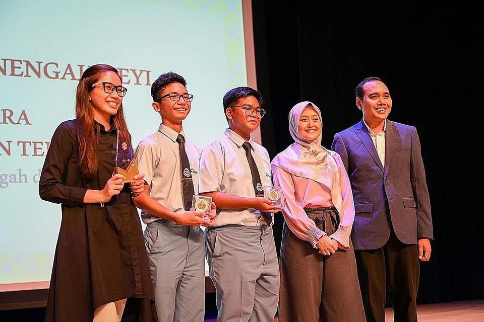 DINOBAT JUARA: Setiausaha Parlimen Kanan (Kesihatan merangkap Undang-Undang), Cik Rahayu Mahzam, yang juga Pengerusi Jawatankuasa Bulan Bahasa (dua dari kanan); dan Timbalan Pengerusi Jawatankuasa Bulan Bahasa dan Anggota Parlimen GRC Chua Chu Kang, Encik Zhulkarnain Abdul Rahim (kanan), bersama Karl Basil Karl Zubin (tengah) dan Muhammad Syahir Syahar (dua dari kiri) dari Sekolah Menengah Deyi yang dinamakan juara Pertandingan TeeVers bagi peringkat sekolah menengah dan maktab rendah, serta Cik Siti Farhanah Mohd Nasir (kiri), guru Bahasa Melayu Sekolah Menengah Deyi dan pembimbing pertandingan. - Foto BH oleh SHAFIQ APANDI