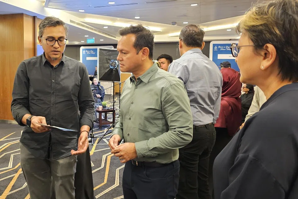 Timbalan Pengarah, Dana Masyarakat Majlis Ugama Islam Singapura (Muis), Encik Shamsul Hadi Jangarodin (kiri), memberi pencerahan tentang Perkampungan Legasi Wakaf Masyarakat Singapura kepada Menteri Negara Kanan (Pertahanan merangkap Tenaga Manusia), Encik Zaqy Mohamad (dua dari kanan).