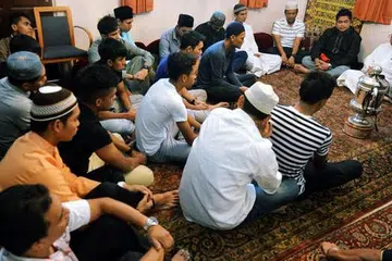 SANTAPAN ROHANI SEBELUM BERBUKA: Pemain LionsXII meluangkan masa mendengar tazkirah yang disampaikan imam Masjid Ba'alwie, Habib Hassan Al-Attas (kanan), sebelum mereka berbuka puasa bersama jemaah di masjid tersebut semalam. - Foto KHALID BABA