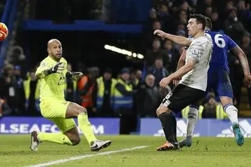 GOL 'OFSAID': John Terry (jersi biru, terlindung) menanduk bola melepasi jangkauan penjaga gawang Everton, Tim Howard. - Foto REUTERS