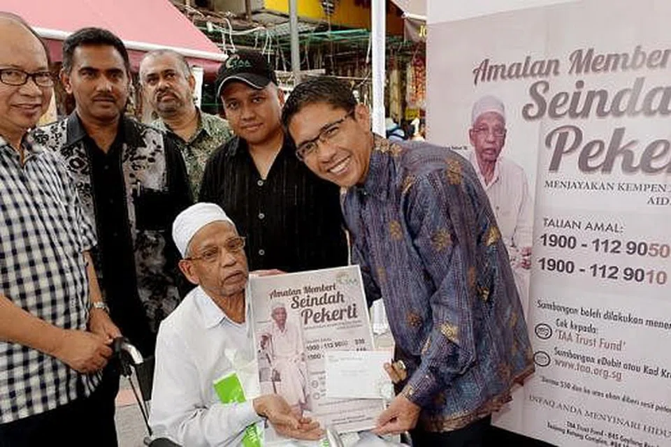 MENJANA SEMANGAT MEMBERI DI LITTLE INDIA: Dr Mohamad Maliki Osman (kanan) bersama penggerak Tabung Amal Aidilfitri (dari kiri) Encik Zulkifli Mohamed, Encik Farihullah Abdul Wahab, Encik Jainlauudin Ibrahim, Encik Muhd Harmizan Abdul Hamid dan penerima bantuan, Encik Chatayan Kara Abdul Kader (duduk di kerusi roda). - Foto TUKIMAN WARJI