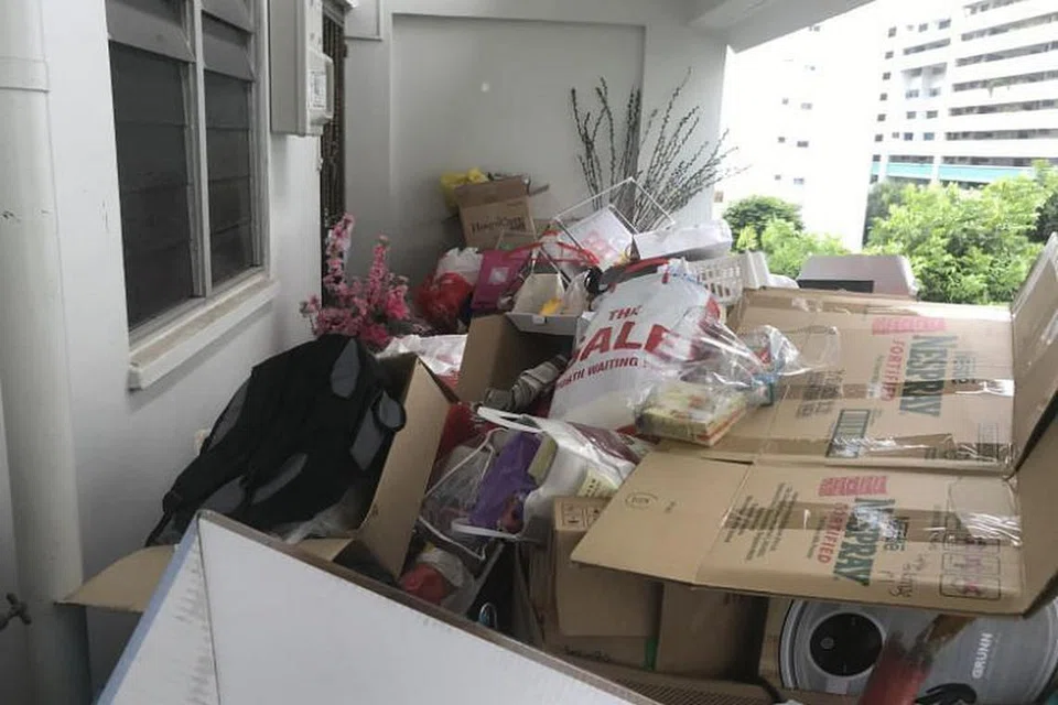 Barang-barang yang bertimbun di luar rumah wanita itu di Blok 522 Hougang Avenue 6. - Foto SHIN MIN DAILY NEWS