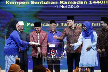 SENTUHAN RAMADAN: (Dari kiri) Pengerusi Mesra, Cik Amatul Jameel Suhani Sujari; Mufti Dr Mohamed Fatris; Dr Mohamad Maliki; Encik Masagos; Encik Esa serta Ketua Pegawai Eksekutif (CEO) Mendaki, Cik Rahayu Buang memasukkan cek ke dalam Tabung Rahmah sebagai satu tanda simbolik melancarkan tabung itu.