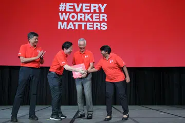 (dua dari kanan) Perdana Menteri Lee Hsien Loong menerima buku khas yang dihasilkan sebagai tanda penghormatan bagi sumbangannya sewaktu Rapat Hari Pekerja pada 1 Mei. Bersamanya ialah (dari kiri) Setiausaha Agung Kongres Kesatuan Sekerja Kebangsaan (NTUC), Encik Ng Chee Meng; Timbalan Perdana Menteri, Encik Lawrence Wong; dan Presiden NTUC, Cik K. Thanaletchimi.