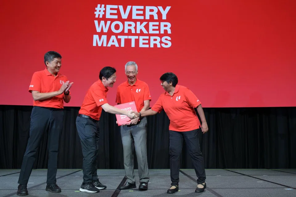 (dua dari kanan) Perdana Menteri Lee Hsien Loong menerima buku khas yang dihasilkan sebagai tanda penghormatan bagi sumbangannya sewaktu Rapat Hari Pekerja pada 1 Mei. Bersamanya ialah (dari kiri) Setiausaha Agung Kongres Kesatuan Sekerja Kebangsaan (NTUC), Encik Ng Chee Meng; Timbalan Perdana Menteri, Encik Lawrence Wong; dan Presiden NTUC, Cik K. Thanaletchimi.