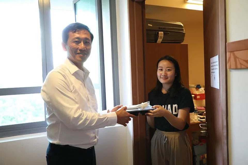 AGIH MAKANAN: Encik Ong tolong mengagih makanan kepada pelajar yang dikenakan LOA di Cinnamon College di NUS.